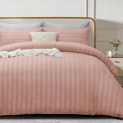 Pink striped bedding set on a bed with a wooden headboard.