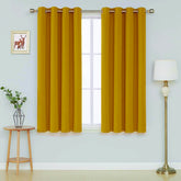 Front view of ochre microfiber blackout curtains hanging in a living room