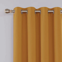 Close-up of metal eyelets on ochre blackout curtain panel
