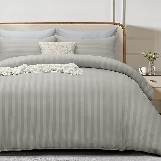 Gray striped bedding set on a bed with a wooden headboard.