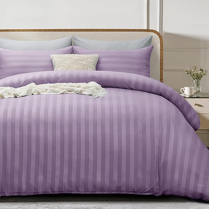 Purple striped bedding set on a bed with a wooden headboard.