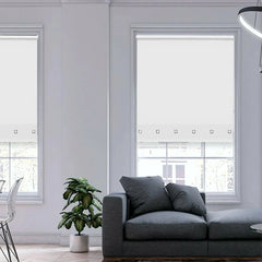 White light filtering roller blind partially lowered in a bright modern room interior