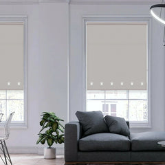 Modern interior featuring light grey square eyelet roller blinds filtering sunlight through large windows.