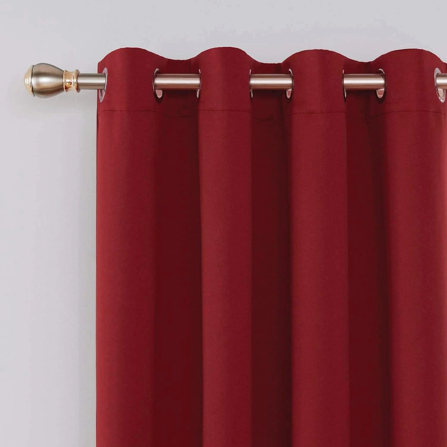 Close-up of metal eyelets on red blackout curtain panel